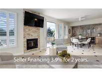 Elegant living room featuring a stone fireplace and adjoining dining area with a wine cooler at 2500 E Cherry Creek South Dr # 306, Denver, CO 80209
