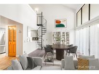 Bright living room features spiral staircase, dining area with bookshelf, and an open layout to the kitchen at 14086 E Stanford Cir # F09, Aurora, CO 80015