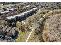 Aerial view of a modern apartment complex adjacent to a walking path and stream at 6000 W Floyd Ave # 307, Denver, CO 80227