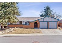 Charming single-story home featuring a brick facade, attached two-car garage, and mature trees at 3762 S Fenton Way, Denver, CO 80235