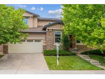 Charming two-story home with stone accents, a well-manicured lawn, and mature trees. A two car garage adds convenience at 2601 Pemberly Ave, Highlands Ranch, CO 80126
