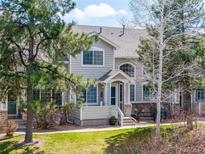 Charming two-story townhome with a covered porch and well-maintained front lawn and mature landscaping at 4027 E Geddes Cir, Centennial, CO 80122