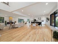 Bright, open-concept living room featuring hardwood floors, modern fireplace, and seamless flow to the kitchen at 4656 Tanglewood Trl, Boulder, CO 80301