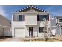 Charming two-story home featuring red shutters, vinyl siding, and an attached one car garage at 4555 Andes St, Denver, CO 80249