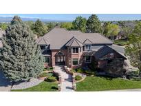 Beautiful two-story home showcasing a manicured lawn, stone pathway, and mature trees at 1193 Phipps Ct, Highlands Ranch, CO 80126
