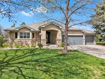Charming ranch-style home with a well-manicured lawn, stone accents, and a welcoming three-car garage at 11 Canon Pl, Greenwood Village, CO 80111