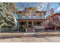 Charming three-story home featuring a covered front porch and mature trees at 1450 N High St # 3, Denver, CO 80218