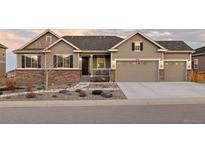 Charming exterior of this two-story home featuring a three car garage and beautifully landscaped front yard at 6728 Mentha Dr, Castle Rock, CO 80108