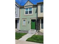Charming two-story townhouse with a green exterior, landscaped front yard, and inviting entrance at 1641 S Idalia Cir # F, Aurora, CO 80017