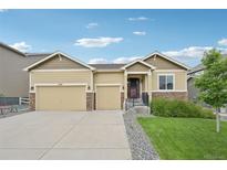 Charming single-Gathering home featuring a three-car garage, stone accents, and a well-manicured front lawn at 17710 E Emilia Dr, Parker, CO 80134