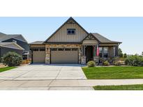 Charming home with a well-maintained lawn, stone accents, and a three-car garage at 7702 E 157Th Ave, Thornton, CO 80602