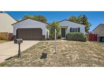 Charming single-story home with a well-maintained lawn and a two-car garage with an extended driveway at 4600 Dillon St, Denver, CO 80239