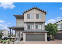 Two-story home featuring neutral siding, brick driveway, attached garage, and a cozy front porch at 19096 E 55Th Ave, Denver, CO 80249