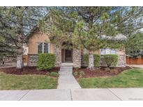 Charming home featuring a stone facade, inviting front entrance, mature trees and manicured landscaping at 529 Uinta Way, Denver, CO 80230