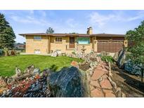 Charming brick ranch-style home with a well-manicured front yard and mature landscaping at 5703 Field St, Arvada, CO 80002