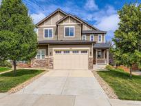 Inviting two-story house with a spacious driveway, beautiful stonework, and a cozy covered front porch at 30 Sun Up Ct, Erie, CO 80516