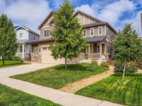 Charming two-story home featuring a well-manicured lawn, stone accents, and an inviting front porch at 30 Sun Up Ct, Erie, CO 80516