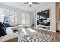 Stylish living room with a large TV, modern furniture, and a sliding door to the outside at 4260 E Warren Ave # 5, Denver, CO 80222