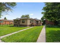 Charming brick home featuring a lush lawn and inviting curb appeal on a sunny day at 1540 Filbert Ct, Denver, CO 80220
