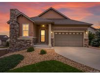 Charming home with a stone chimney and well-maintained landscaping during an eye-catching sunset at 2351 Lassen Ln, Castle Rock, CO 80109