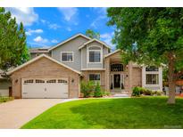 Charming two-story home with a brick facade, lush lawn, and well-maintained landscaping at 2061 Chesapeake Pl, Highlands Ranch, CO 80126