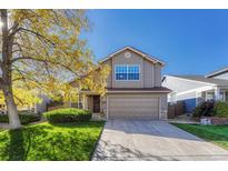 Charming two-story home featuring a well-manicured lawn, gray siding, and attached two-car garage at 3144 White Oak St, Highlands Ranch, CO 80129