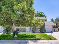 Charming home with mature tree, lush lawn, and welcoming front entrance at 1576 S Ursula Ct, Aurora, CO 80012