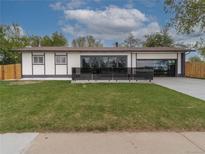 Charming single-story home featuring a well-manicured lawn and modern design elements at 6735 W 2Nd Ave, Lakewood, CO 80226