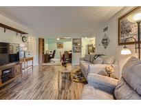 Open-concept living area with hardwood floors and plenty of natural light at 3141 S Tamarac Dr # 110G, Denver, CO 80231