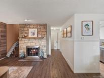 Cozy living room featuring a stone fireplace, wood floors, and warm, inviting decor at 1935 W 102Nd Ave, Thornton, CO 80260