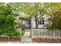 Charming home exterior featuring a well-manicured lawn, mature tree, and inviting white picket fence at 2552 Stonewall Ln, Lafayette, CO 80026