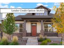 Charming home featuring stone accents, a cozy porch, and a well-manicured front yard at 20968 E 60Th Pl, Aurora, CO 80019