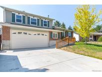 Charming two-story home featuring a two-car garage and a well-maintained front yard with a tree in full bloom at 11073 Newland St, Westminster, CO 80020