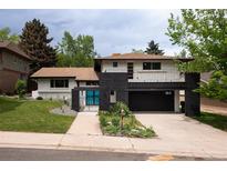 Two-story home featuring a two-car garage, charming balcony and a black brick facade at 7453 E Jefferson Dr, Denver, CO 80237