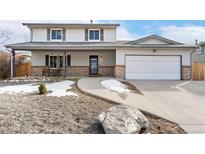 Charming two-story home boasts a covered porch, updated garage door and rock landscaping at 11936 W Temple Dr, Morrison, CO 80465