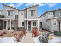 Stylish townhome with gray siding, stone accents, and well-maintained landscaping at 17217 E Exposition Dr, Aurora, CO 80017