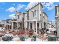 Two-story townhome with gray siding, front porch, and landscaping at 17217 E Exposition Dr, Aurora, CO 80017