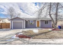 Charming single-story home featuring a purple exterior, attached garage and newly landscaped front yard at 8722 Dudley Ct, Arvada, CO 80005