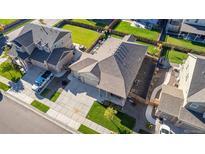 Aerial view of a well-maintained home with a two-car garage, fenced backyard, and manicured lawn at 697 Gamble Oak St, Brighton, CO 80601
