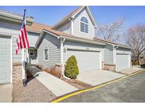 Charming two-story home with a gray exterior, attached garage and a beautifully maintained front yard at 5960 S Jellison St # B, Littleton, CO 80123