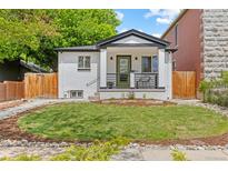 Charming white brick home with green door, black trim, and a well-manicured lawn and landscaping at 1845 W 39Th Ave, Denver, CO 80211