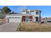 Charming two-story home featuring a manicured lawn and a convenient two-car garage at 145 Willowleaf Dr, Littleton, CO 80127