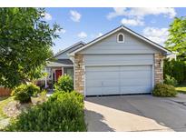 Charming home featuring a two-car garage, stone accents, and mature landscaping enhancing its curb appeal at 607 Branding Iron Ln, Castle Rock, CO 80104