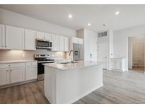 Bright kitchen featuring white cabinets, stainless steel appliances, and an island with quartz countertops at 487 Interlocken Blvd # 409, Broomfield, CO 80021