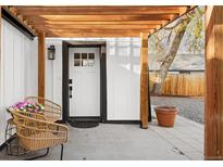 Inviting seating area and front door under a pergola, enhanced by a potted plant at 1755 Ingalls St, Lakewood, CO 80214
