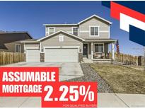 Inviting two-story home featuring a three-car garage and a charming front porch, creating a welcoming curb appeal at 5995 Fencerow Pl, Brighton, CO 80601