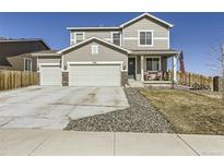 Charming two-story home featuring a three-car garage, inviting front porch, and beautiful curb appeal at 5995 Fencerow Pl, Brighton, CO 80601