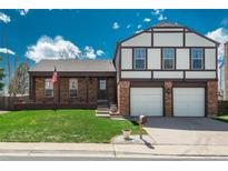 Charming two-story home featuring a brick facade, attached two-car garage, and well-manicured lawn at 15930 E Ford Pl, Aurora, CO 80017