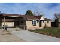 A lovely single-story home with brick exterior, fenced yard, and attached carport at 6087 W 61St Pl, Arvada, CO 80003