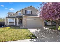 Charming two-story home featuring a well-manicured lawn and a beautiful flowering tree in the front yard at 13846 Harrison Dr, Thornton, CO 80602